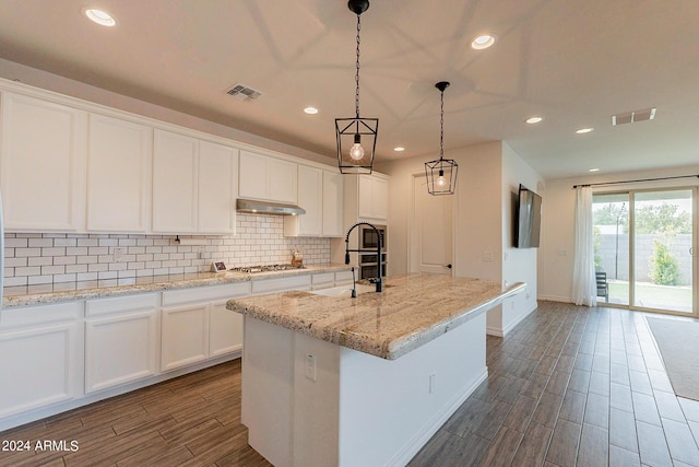 3023 W New River Dr, San Tan Valley, AZ 85144 - kitchen featuring decorative backsplash, stainless steel gas cooktop, under cabinet range hood, and visible vents