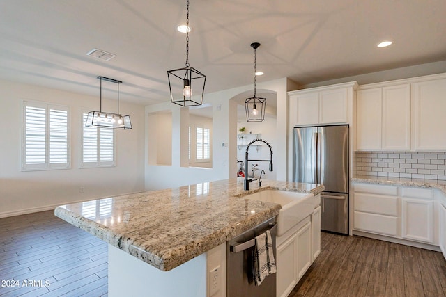 3023 W New River Dr, San Tan Valley, AZ 85144 - kitchen featuring an island with sink, a sink, tasteful backsplash, stainless steel appliances, and dark wood-style flooring
