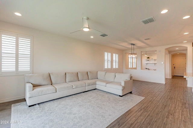 3023 W New River Dr, San Tan Valley, AZ 85144 - living room with wood finished floors, arched walkways, ceiling fan, and visible vents