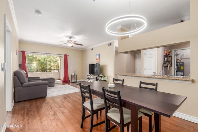 5345 E Van Buren St Unit 258, Phoenix, AZ 85008 - dining space featuring crown molding, wood finished floors, and ceiling fan