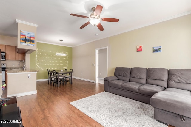 5345 E Van Buren St Unit 258, Phoenix, AZ 85008 - living room featuring baseboards, ceiling fan, wood finished floors, and ornamental molding