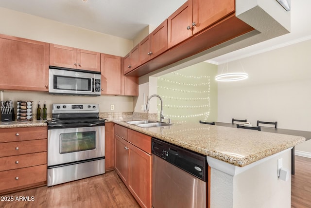 5345 E Van Buren St Unit 258, Phoenix, AZ 85008 - kitchen featuring a sink, stainless steel appliances, light wood-style floors, and a peninsula
