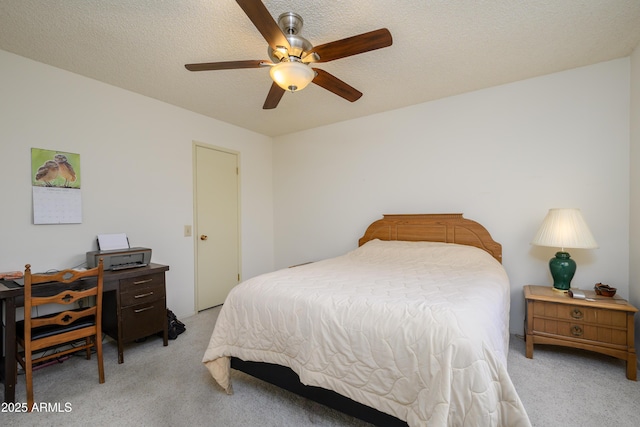 carpeted bedroom featuring ceiling fan and a textured ceiling