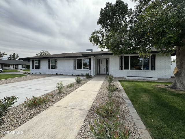 ranch-style house with brick siding and a front lawn