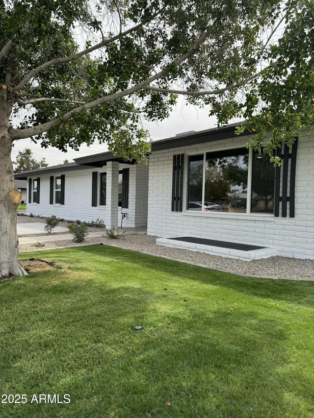 ranch-style house with a front lawn and brick siding