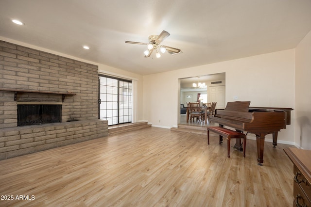 1454 W Capri Ave, Mesa, AZ 85202 - living room featuring a ceiling fan, light wood-style floors, a brick fireplace, a chandelier, and recessed lighting