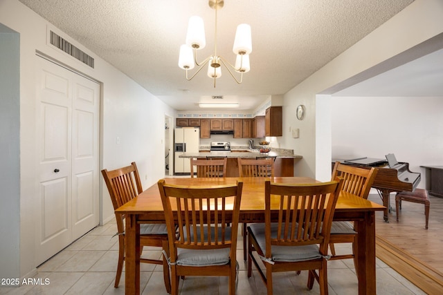 1454 W Capri Ave, Mesa, AZ 85202 - dining area featuring a chandelier, a textured ceiling, and light tile patterned flooring