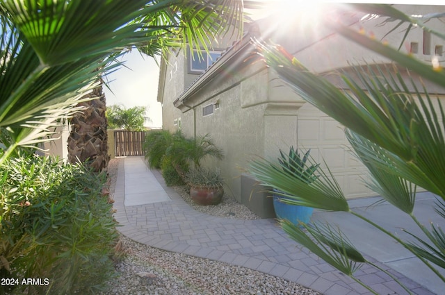 view of property exterior with a garage, a gate, and stucco siding