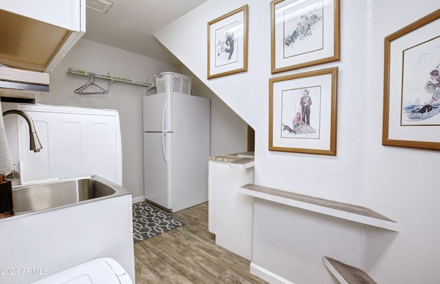 interior space featuring visible vents, wood finished floors, a sink, and freestanding refrigerator