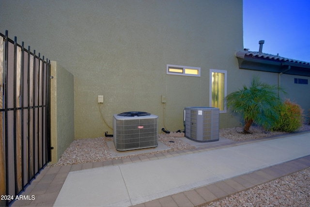 exterior details featuring fence, cooling unit, and stucco siding