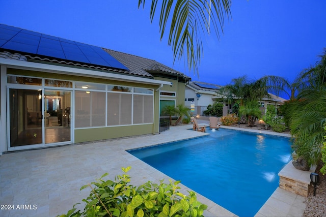 outdoor pool featuring a sunroom and a patio