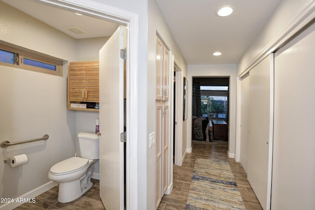 hallway with wood tiled floor, visible vents, baseboards, and recessed lighting