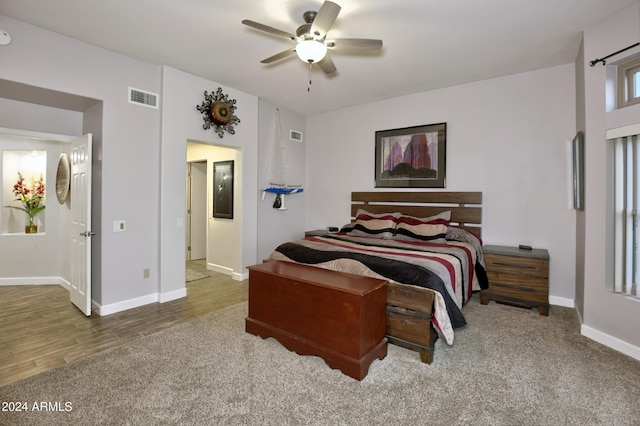 bedroom featuring visible vents, ceiling fan, baseboards, and wood finished floors