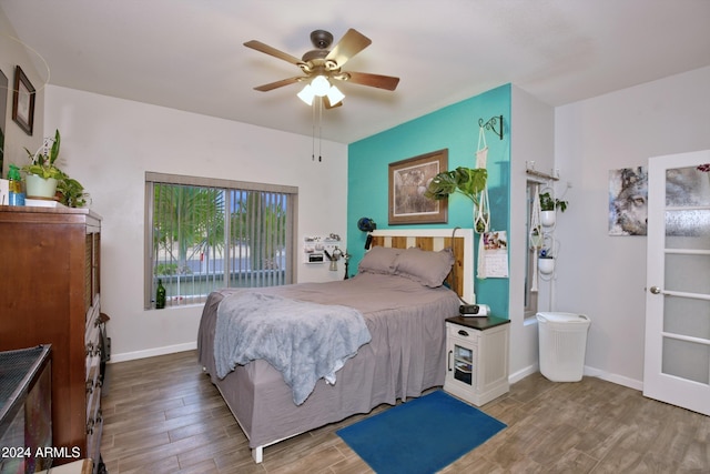 bedroom featuring a ceiling fan, baseboards, and wood finished floors