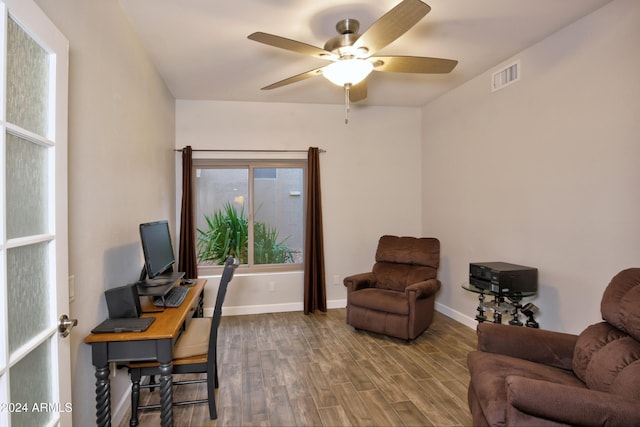 office area featuring a ceiling fan, visible vents, baseboards, and wood finished floors