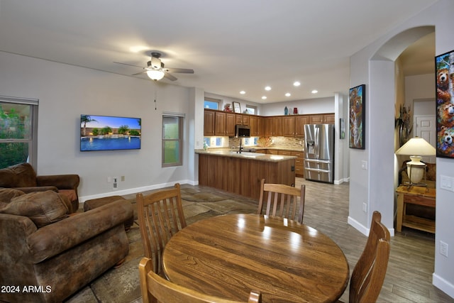 dining room with arched walkways, recessed lighting, a ceiling fan, light wood-style floors, and baseboards