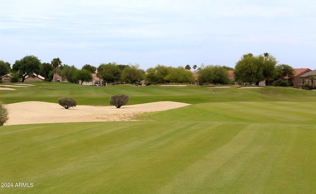 view of home's community featuring view of golf course and a yard