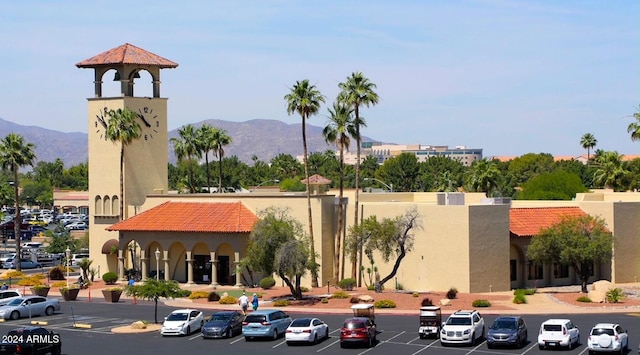 view of building exterior featuring uncovered parking and a mountain view