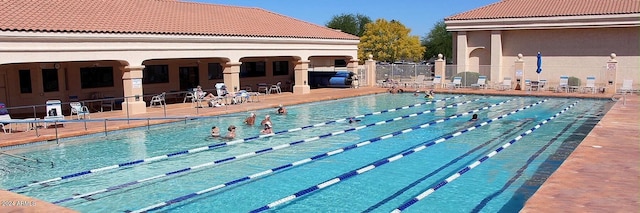 community pool featuring a patio area and fence