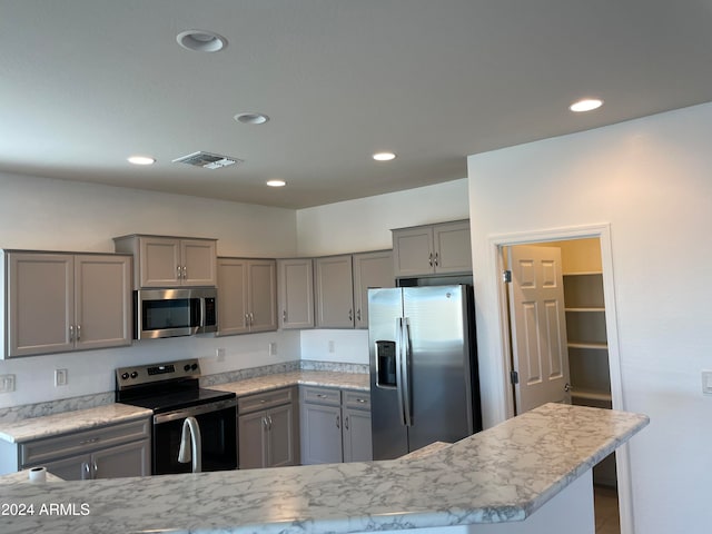 kitchen featuring stainless steel appliances and gray cabinets