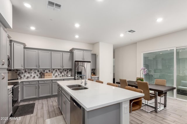 286 E Raleigh Dr, Chandler, AZ 85286 - kitchen featuring gray cabinets, a sink, appliances with stainless steel finishes, decorative backsplash, and light countertops
