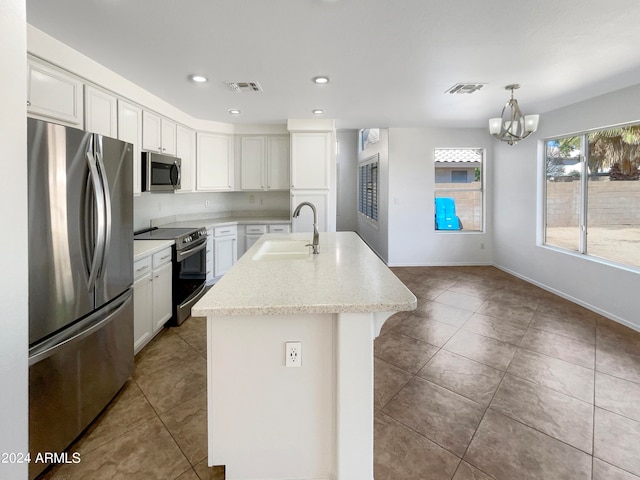 kitchen featuring a kitchen island with sink, pendant lighting, sink, appliances with stainless steel finishes, and white cabinets