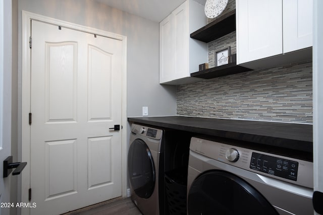 washroom with dark hardwood / wood-style flooring, separate washer and dryer, and cabinets