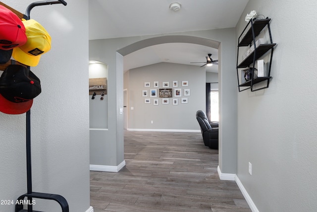 hallway featuring wood-type flooring and vaulted ceiling