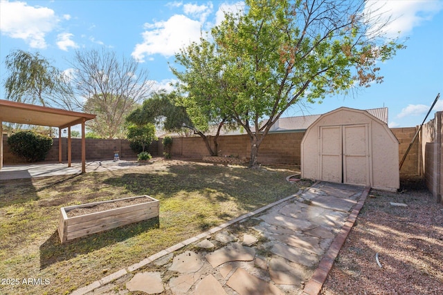 view of yard featuring a storage unit, an outbuilding, a fenced backyard, and a patio area