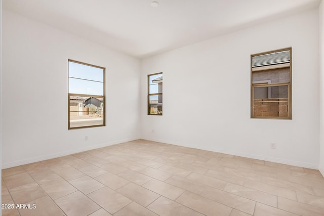 unfurnished room with baseboards