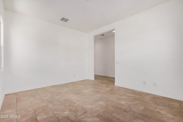 spare room with baseboards and visible vents