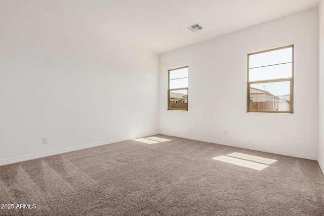 carpeted empty room with baseboards and visible vents