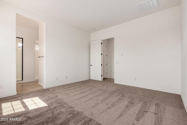 unfurnished bedroom with baseboards, visible vents, and carpet
