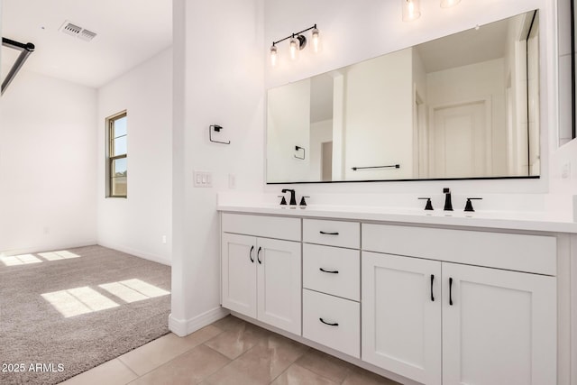 bathroom with a sink, visible vents, baseboards, and double vanity