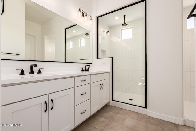 full bathroom featuring a stall shower, double vanity, tile patterned flooring, and a sink