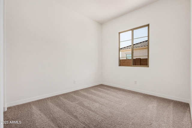 empty room featuring baseboards and carpet