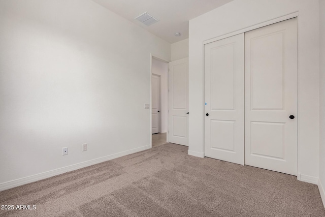 unfurnished bedroom featuring baseboards, visible vents, a closet, and carpet