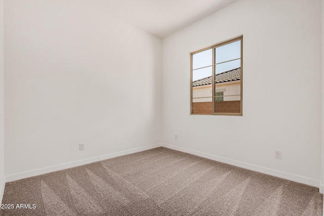 carpeted spare room featuring baseboards