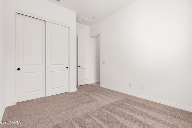 unfurnished bedroom featuring a closet, visible vents, baseboards, and carpet