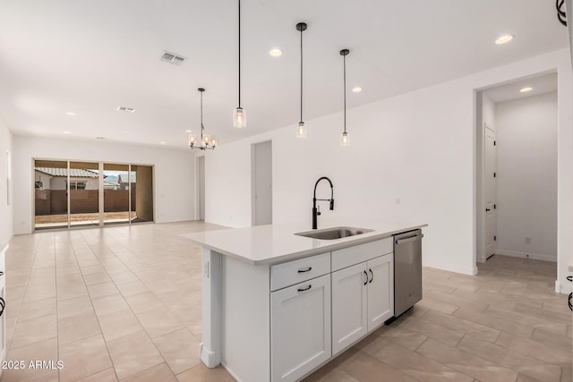kitchen featuring light countertops, stainless steel dishwasher, a sink, visible vents, and a notable chandelier