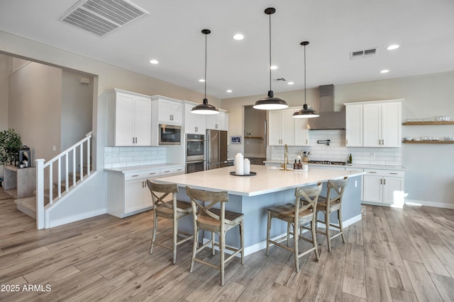 826 E Buist Ave, Phoenix, AZ 85042 - kitchen featuring wall chimney range hood, stainless steel appliances, backsplash, light wood-type flooring, and recessed lighting