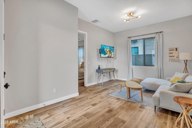 826 E Buist Ave, Phoenix, AZ 85042 - sitting room with light wood finished floors, baseboards, and a chandelier