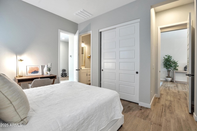 826 E Buist Ave, Phoenix, AZ 85042 - bedroom with light wood-style flooring, baseboards, connected bathroom, and a closet
