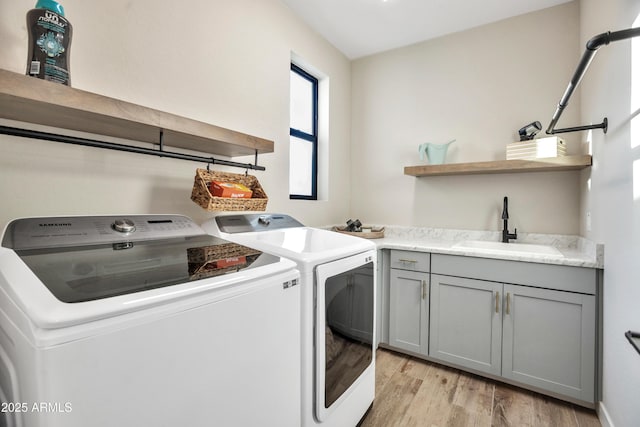 826 E Buist Ave, Phoenix, AZ 85042 - laundry room with washing machine and dryer, light wood finished floors, and cabinet space