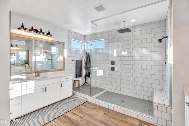 826 E Buist Ave, Phoenix, AZ 85042 - bathroom featuring wood finished floors, a tile shower, and vanity