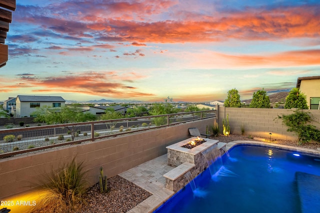 826 E Buist Ave, Phoenix, AZ 85042 - pool at dusk featuring an outdoor fire pit, a fenced backyard, and a patio