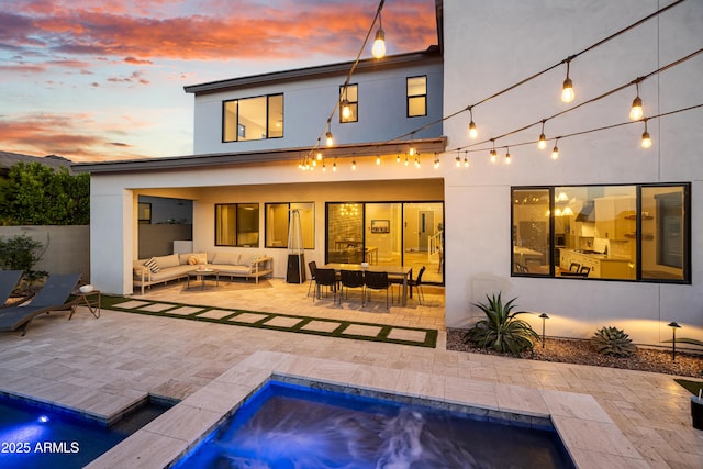 826 E Buist Ave, Phoenix, AZ 85042 - back of house at dusk with an outdoor hangout area, stucco siding, a patio area, and an outdoor pool