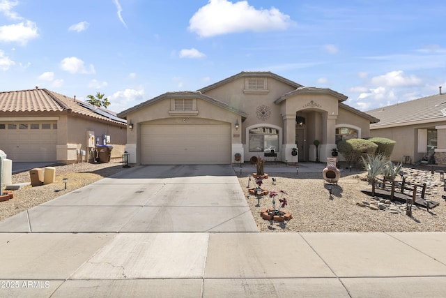 mediterranean / spanish-style house featuring a tiled roof, stucco siding, an attached garage, and concrete driveway