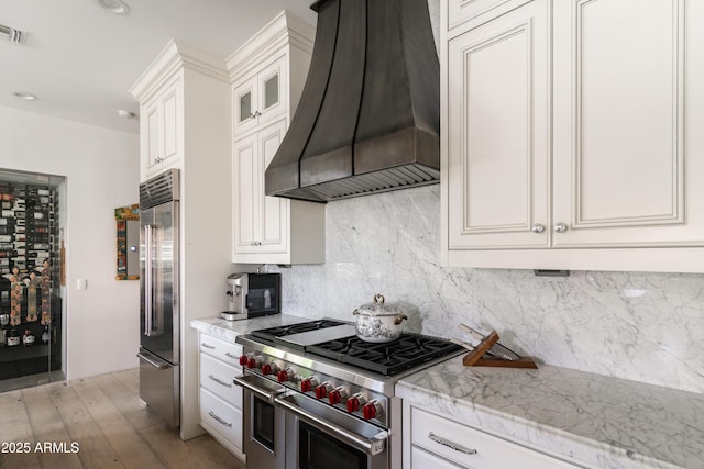 3511 N 39th Pl, Phoenix, AZ 85018 - kitchen featuring custom range hood, high end appliances, tasteful backsplash, light wood-style floors, and light stone countertops
