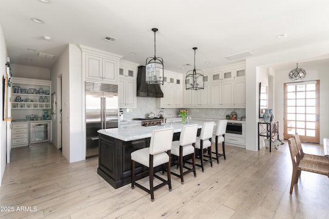 3511 N 39th Pl, Phoenix, AZ 85018 - kitchen featuring stainless steel built in fridge, a chandelier, premium range hood, decorative backsplash, and a breakfast bar